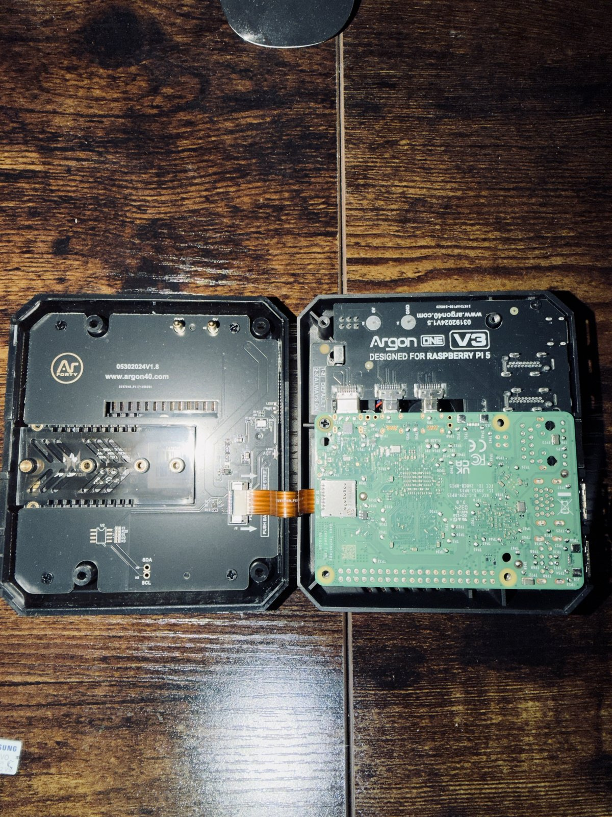 Raspberry Pi 5 mounted in an opened Argon ONE V3 case with the M.2 NVMe board connected by a ribbon cable